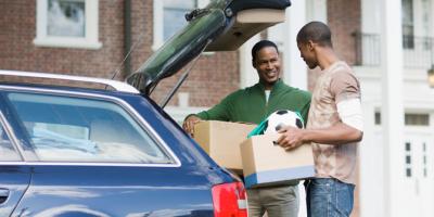 Father and son unpacking car on first day of college