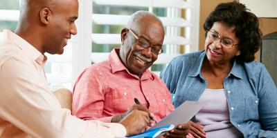 Financial Advisor Talking To Senior Couple At Home