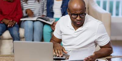 Man using calculator while looking at bills