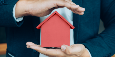 Hands holding a toy house