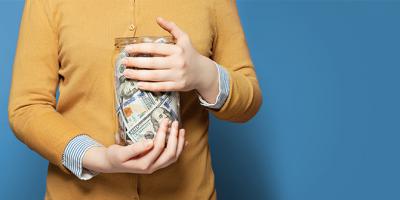 Hands holding jar full of money