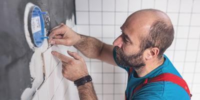 Man installing tiles on bathroom wall