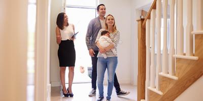 Real estate agent showing family around property for sale