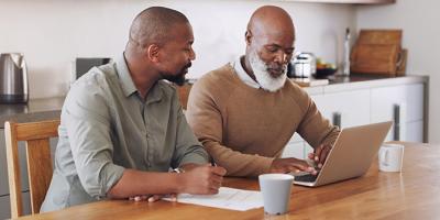 Younger man helping his father with finances