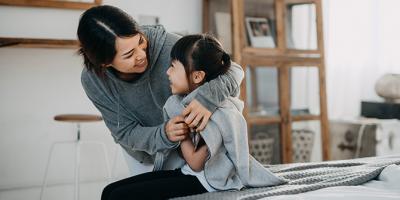 Mom wrapping daughter in a jacket