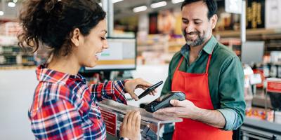 Woman using contactless payment at checkout