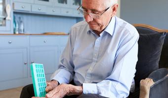 Older man holding medicine container