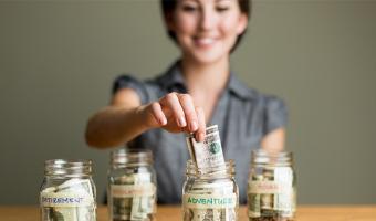 Woman putting money into a jar labeled "adventure"