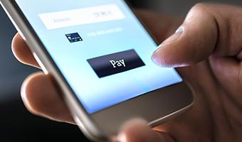 Close-up of a hand making a mobile payment on a smart phone. 