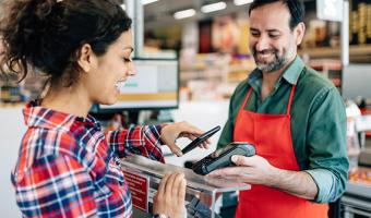 Woman using contactless payment at checkout